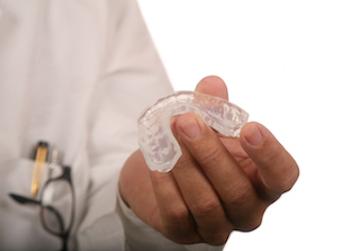 A dentist holding an invisalign in Northborough MA