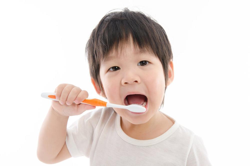 young boy brushing teeth