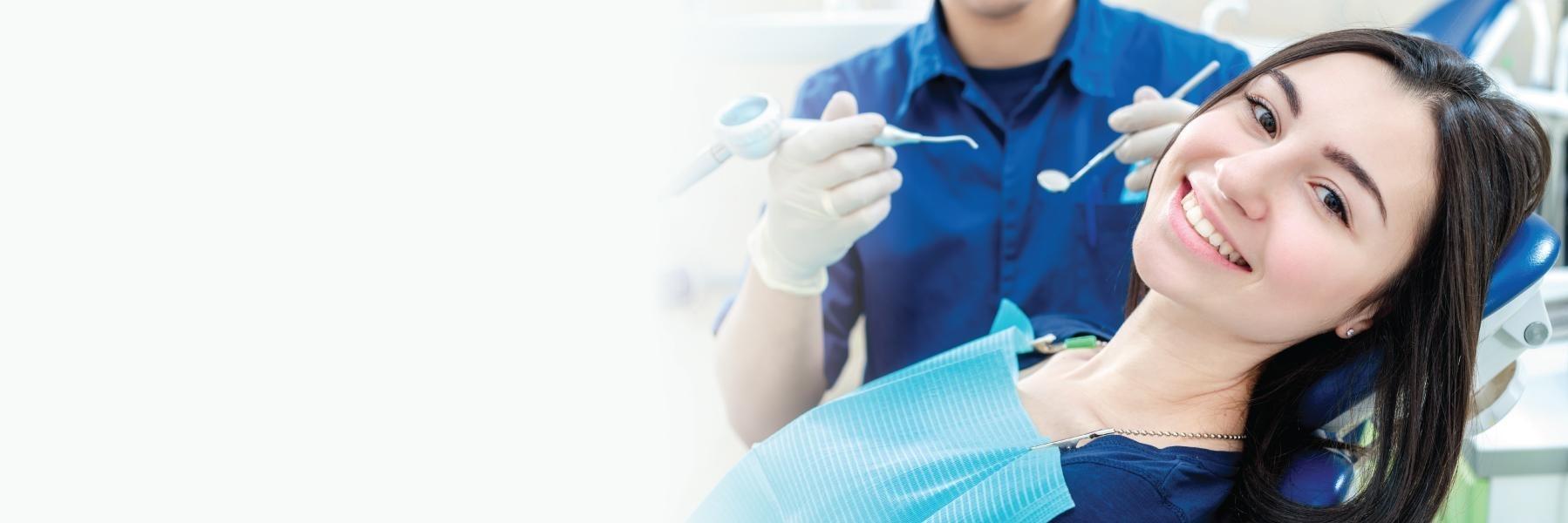 woman smiling while sitting in chair in safe dental office