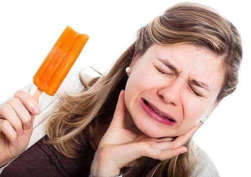 A woman showing tooth sensitivity after eating an Ice cream in Northborough