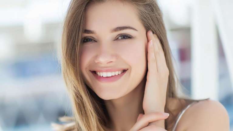 A lady hiding her ears with refreshing white teeth in Northborough